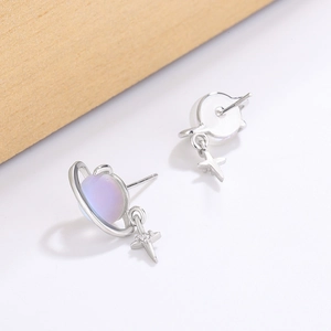 Saturn-inspired earrings with iridescent gradient globes and hanging star charms