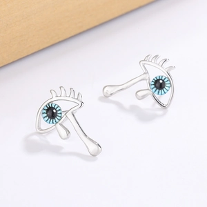 Gothic evil eye stud earrings with silver lashes and blue teardrop crystal detail