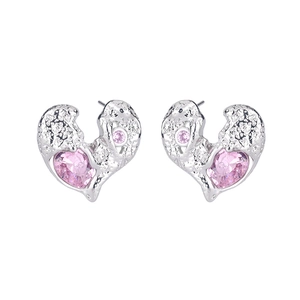 Macro shot of silver heart earrings with textured finish and pink zircon stones