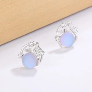 Macro detail of silver fishtail planet earrings with blue moonstone and zircon accents