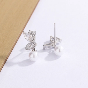 Gros plan de boucles d'oreilles papillon avec strass marquise et perles blanches élégantes