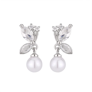 Détail de boucles d'oreilles papillon en argent avec zircons et perles blanches rondes