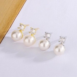 Detailed view of elegant gold and silver pearl earrings with sparkling zircon studs