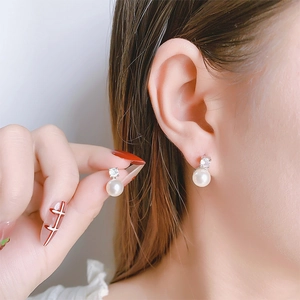 Detail of elegant pearl stud earrings with zircon inlay on a silver metal base