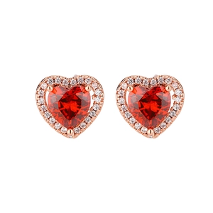 Detailed macro shot of heart-shaped earrings with red zircon and rose gold plating