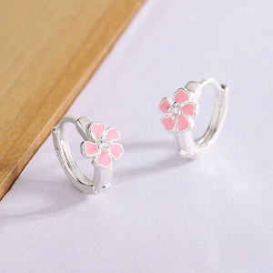 Vue détaillée du poinçon S925 sur des boucles d'oreilles fleurs de cerisier en émail rose