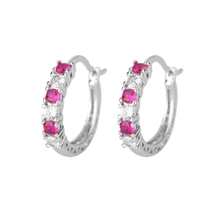 Detail of silver hoop earrings with alternating pink and white zircons and hollow patterns