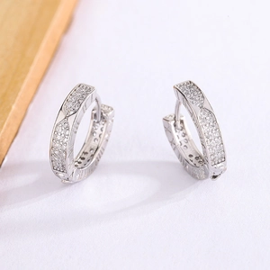Macro shot of men's hoop earrings featuring Roman numerals and white zircon pavé setting