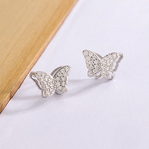 Detailed view of silver butterfly earrings with sparkling cubic zirconia on a minimalist background