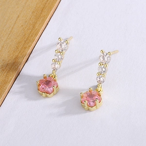 Gros plan sur les boucles d'oreilles étoile rose avec finition dorée et cristaux