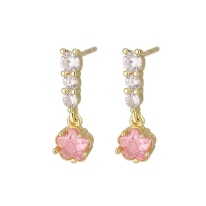Détail de boucles d'oreilles étoile en zircon rose avec métal doré et pierres