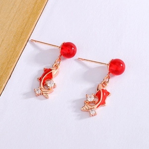 Macro shot of koi fish drop earrings with red enamel and sparkling crystal accents