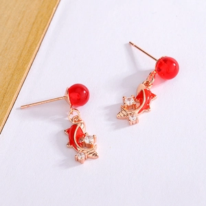 Macro detail of red koi fish earrings with rose gold plating and red tassel bead