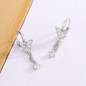 Close-up of silver butterfly tassel earrings with delicate chains and sparkling zircon