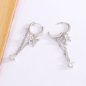 Close-up of silver butterfly tassel earrings with zircon charms and polished finish