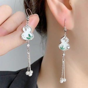 Detail of Chinese gourd earrings with green bamboo leaves, tassels, and pearls