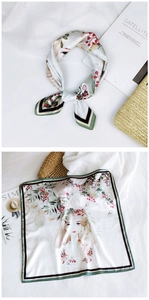 Detail of square silk scarf featuring floral illustration and geometric borders