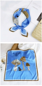 Detail of light blue square silk scarf featuring mushroom illustration and tiled layout