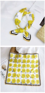 Detail of floral silk scarf with yellow flower print and black bordered edges for women