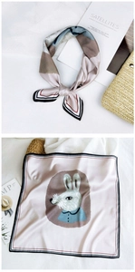 Detail view of a pink silk square scarf featuring a rabbit print and striped edges