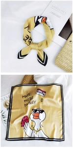 Detail of square yellow silk scarf with cartoon duck pattern and money motif design