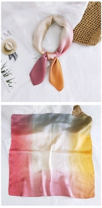 Close-up of a gradient silk square scarf with pink, orange, and olive green silky textures
