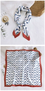 Detail of square silk scarf with blue wave pattern and red edges for women's styling