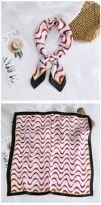 Detailed view of square silk scarf with red and white wave pattern and black borders