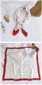 Detail of silk square scarf with golden wave pattern and bold red borders on white