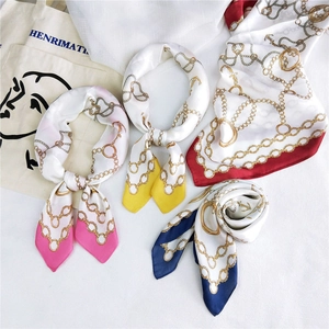 Detail of silk square scarves with gradient colors and vintage gold chain patterns