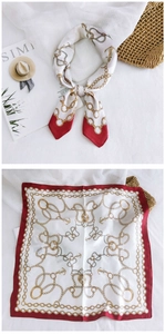Detail of nautical print silk scarf with anchors and gold chains in red and white colors