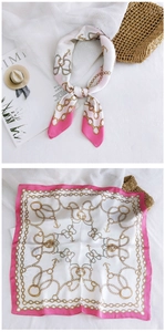 Detail of square silk scarf with nautical gold chain patterns and pink border accents