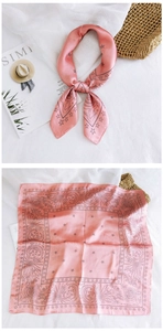 Detail of satin square scarf featuring celestial sun and moon patterns in soft pink