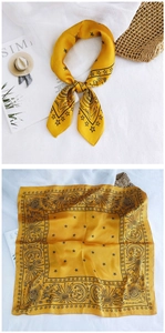 Detail of yellow satin silk scarf featuring black celestial sun and star patterns