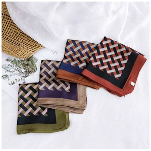 Macro detail of four assorted silk scarves with elegant geometric patterns and satin texture
