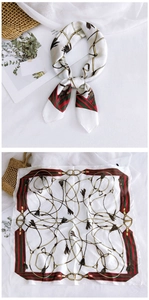 Detail of silk square scarf featuring gold chains, tassels, and iconic striped borders