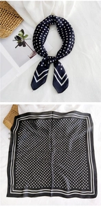Detail of elegant black and white polka dot silk scarf with striped borders