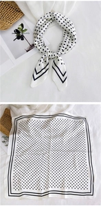 Close-up of square silk scarf with classic black polka dots and sleek border detail