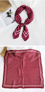 Close-up of burgundy silk square scarf featuring white polka dots and striped border