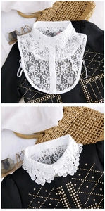 Détail d'un faux col en dentelle blanche avec broderie florale et détails de boutons