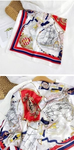 Detail of nautical print silk scarf featuring sailboat motifs and red blue striped borders