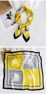 Detailed view of yellow and grey silk scarf showing elephant and paisley patterns