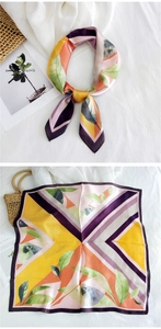 Detail of silk scarf showing vibrant geometric blocks and green leaf pattern texture