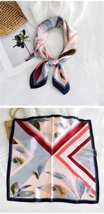 Detailed view of square satin silk scarf with leaf prints and geometric color blocking