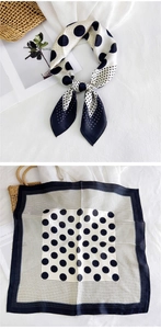 Detail of a black and white polka dot silk scarf featuring a gradient pattern design