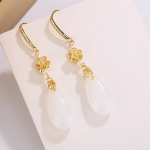 Détail de boucles d'oreilles lotus plaquées or 14K avec pierres blanches et crochets S925