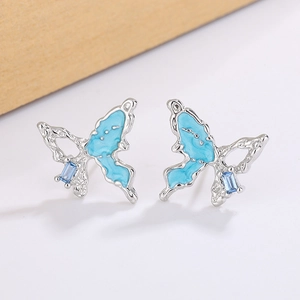 Gros plan détaillé de boucles d'oreilles papillon avec émail bleu et zircone