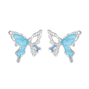 Détail de boucles d'oreilles papillon avec zircon bleu et finitions en émail argenté