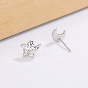Macro view of silver star and moon stud earrings with rock texture and hammer finish