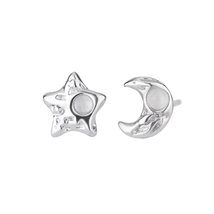 Detailed close-up of silver star and moon earrings with hammered metal texture and white opal